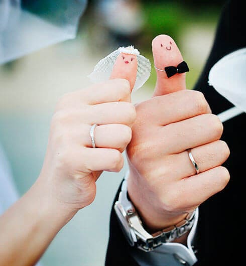 невеста и жених на фотосессию свадьбы показывают разрисованные большие пальцы 