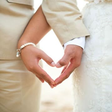 Жених и невеста  руками около ступни ног образуют символ сердца 