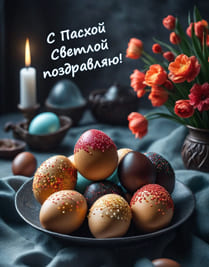 Пасхальные яйца на тарелке и зажжённая свеча с красными цветами