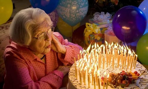 Бабушка задувает свечи на свой день рождения после поздравлений в стихах