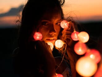 девушка держит лампочки гирлянды для фото пример
