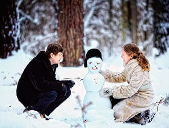 Зимняя фото в лесу девушка и парень лепят снеговика   