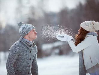 Девушка дует  снег на лицо парня зимняя фото в лесу 